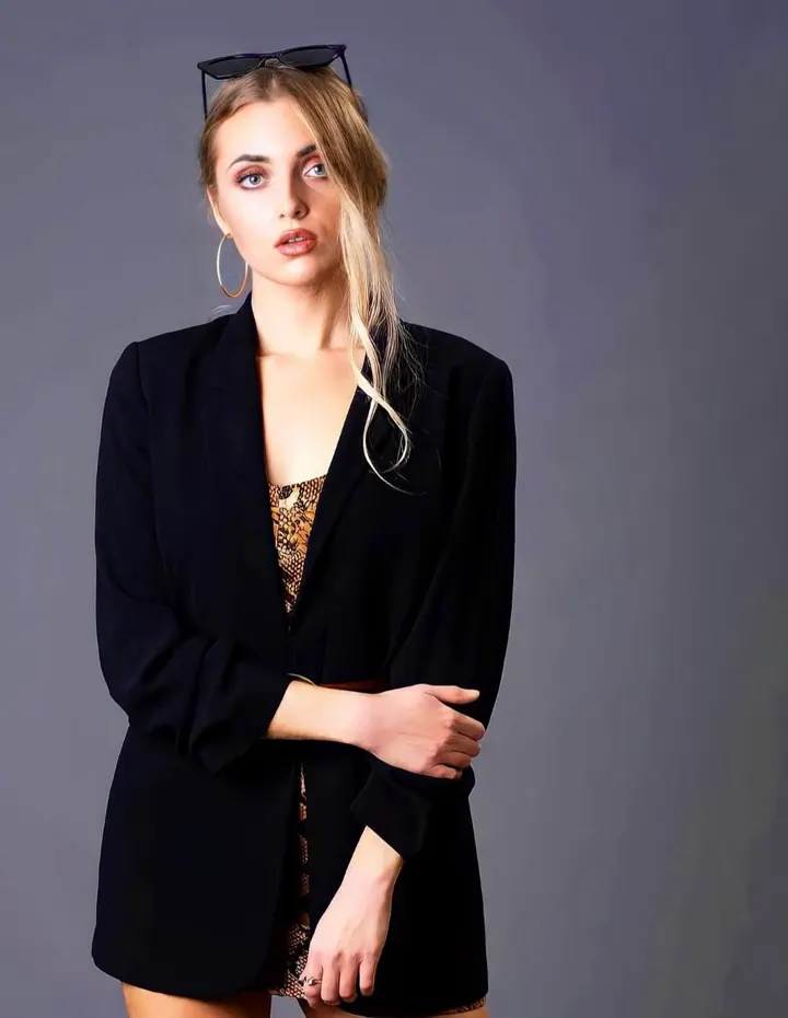 Paula Maria Rosalia in a black blazer against a grey studio backdrop