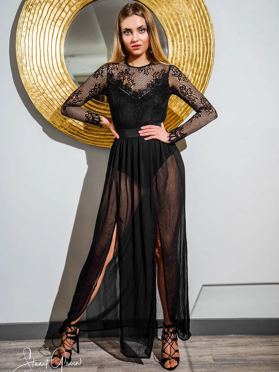 Paula Maria Rosalia in black sheer fashion styling with a gold circular backdrop